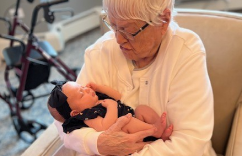 Sister Jeanne Landry whispers to Baby Noona.