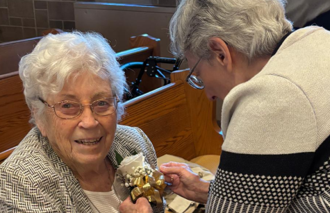 Sister Theresa Lamy helps Sister Mary Rose Crowley with her corsage