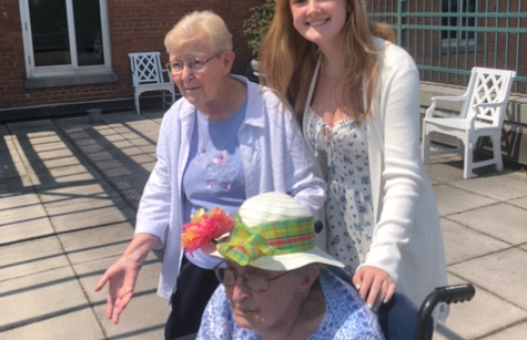 Sisters Kathleen Boland (standing) and Pat Hogan enjoy the weather with an NDP Intern.